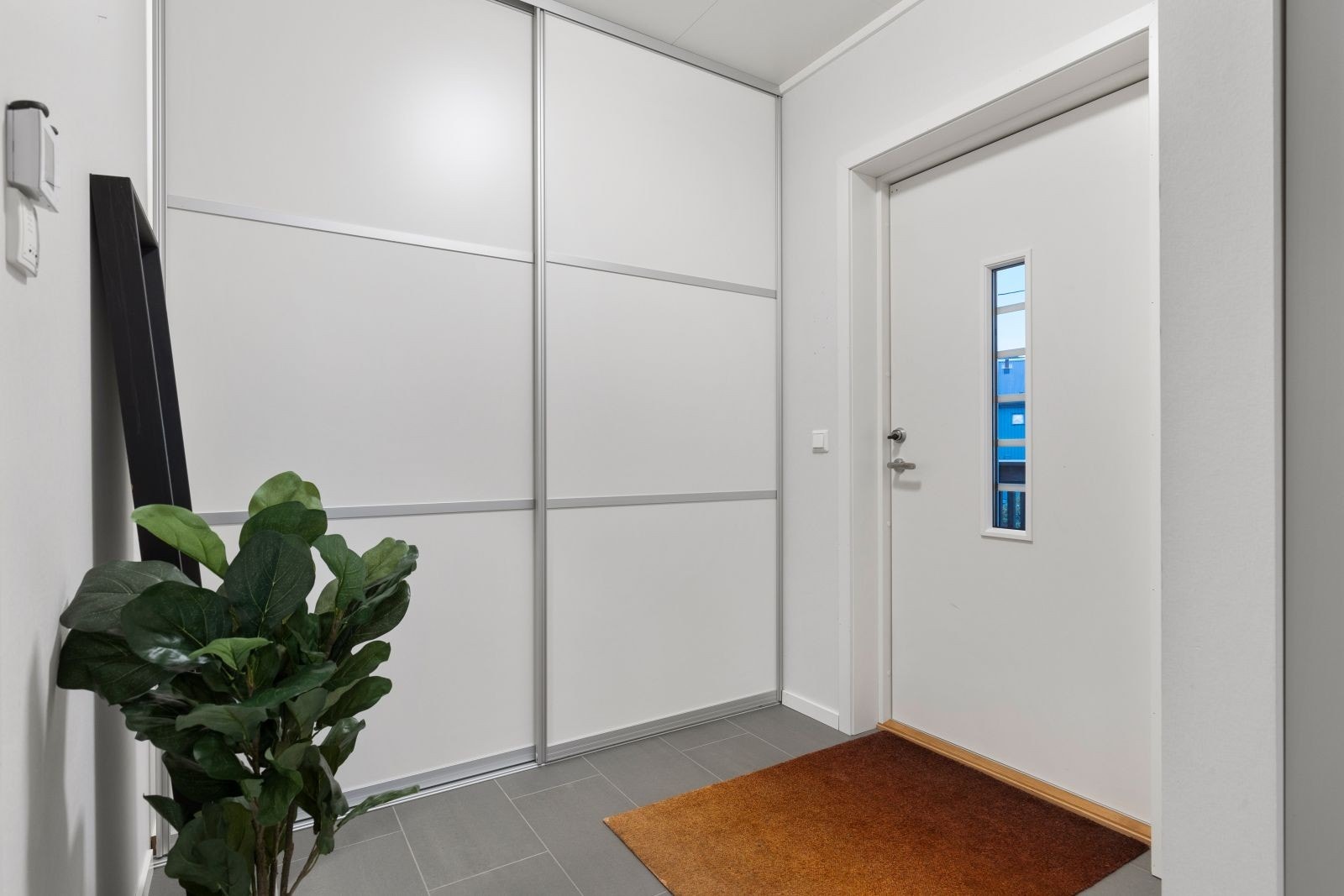 Entre med skyvedørsgarderobe og varmekabler i gulv. Galleribilde