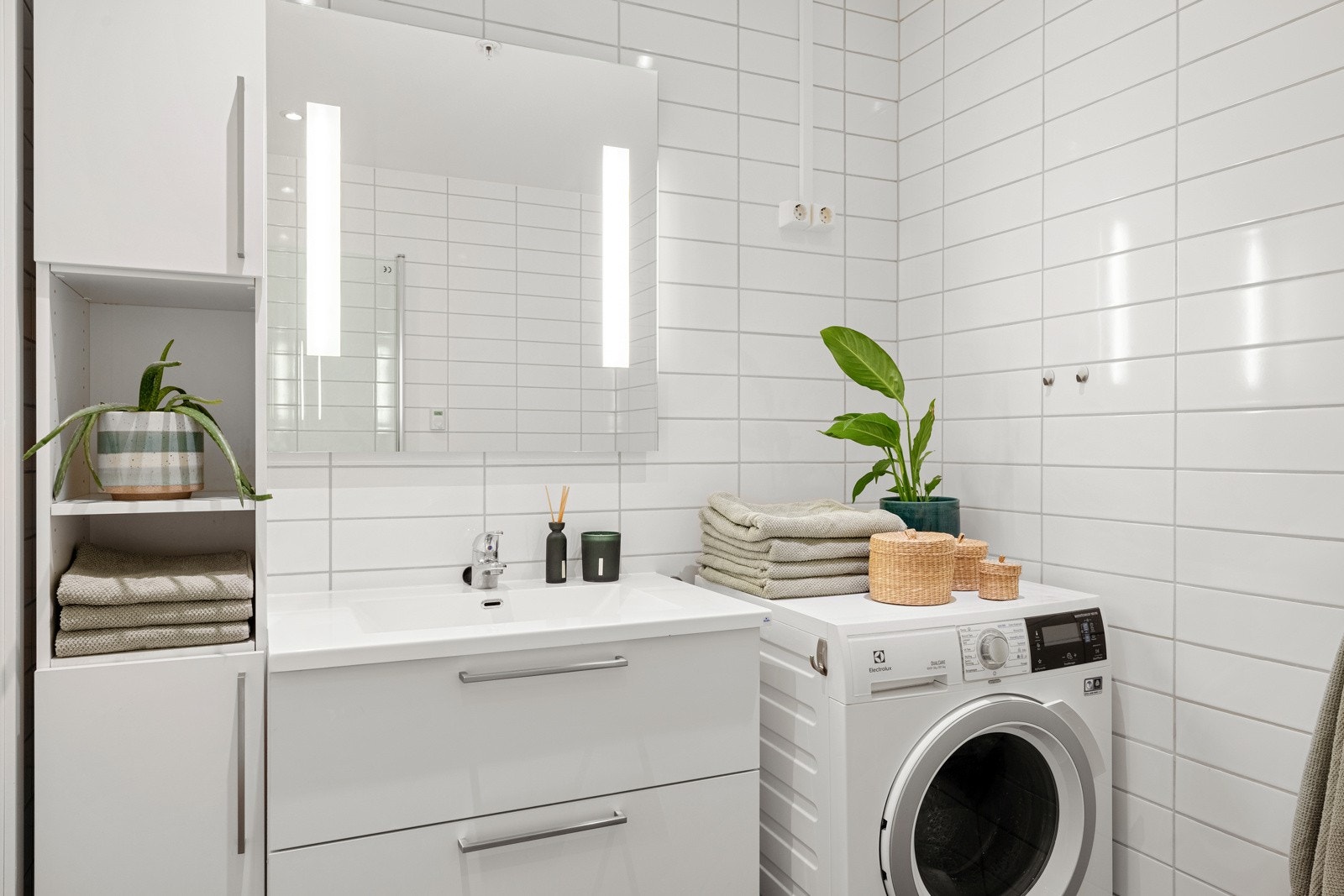 Badet er innredet med vegghengt toalett, dusj med glassvegger, opplegg for vaskemaskin og baderomsinnredning. Galleribilde