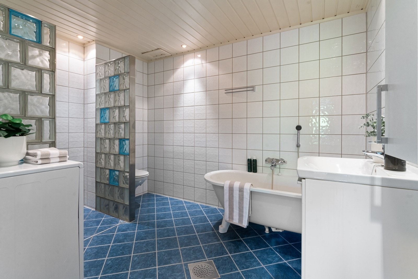 Stort flislagt bad med varmekabler i gulv og downlights i himlingen. Galleribilde