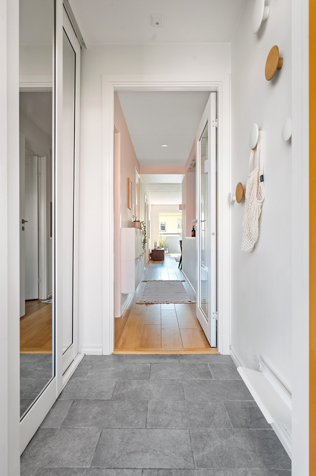 Praktisk entré med dørcalling og varme i gulv. Entréen har skyvedørsgarderobe langs den ene veggen med god plass til oppbevaring av sko og yttertøy. Galleribilde