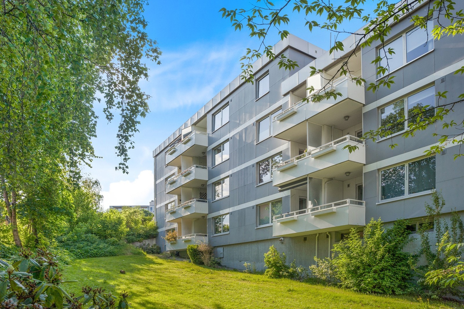 Tomten er pent opparbeidet med gressplen, beplantning og interne stikkveier. Galleribilde