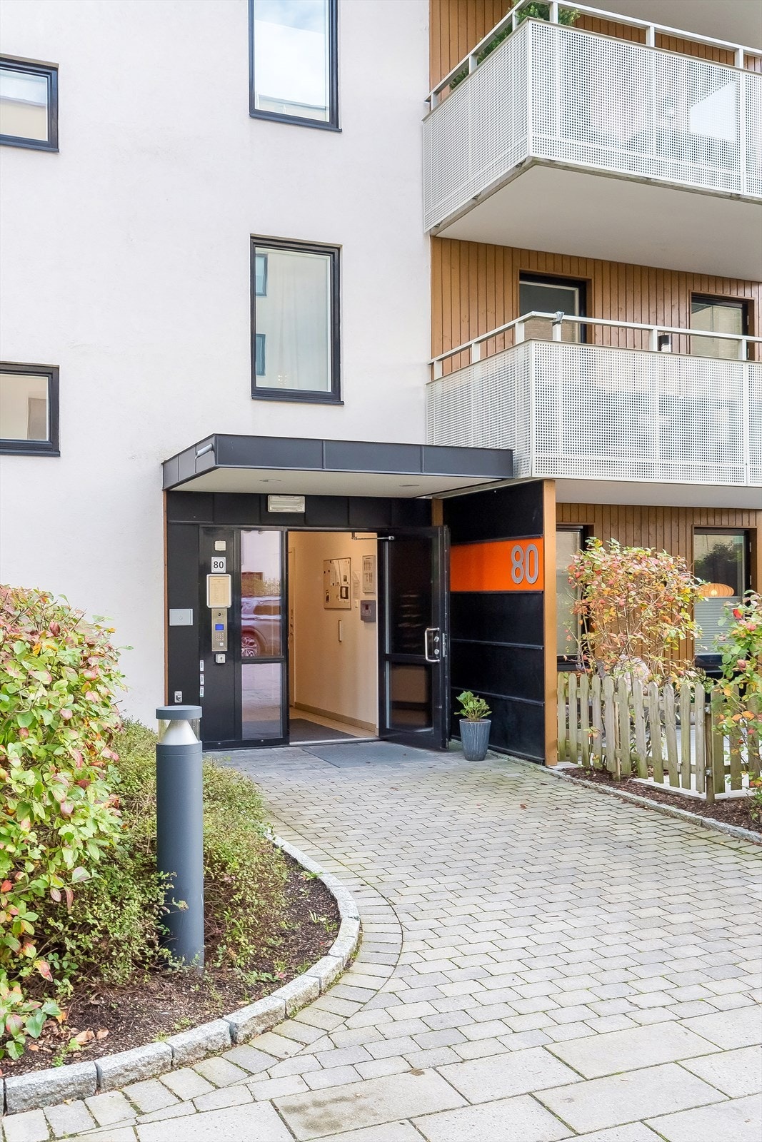 Inngangspartiet er pent opparbeidet med hellebelagt gangvei og beplantning. Galleribilde