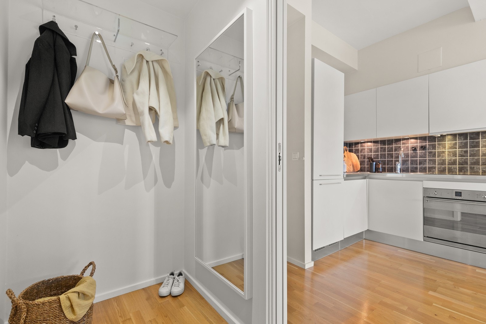 Entreen har nedsenket himling med led-downlights, knagger på vegg, skyvedør inn til stue/kjøkken og dør inn til badet. Galleribilde