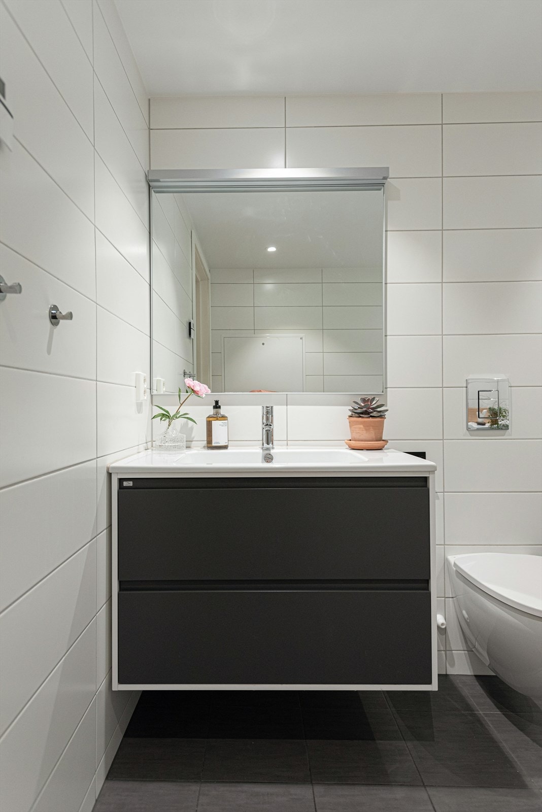 Servantskap med glatte fronter fra Lindbad. Overlimt servant fra Lindbad med ettgreps armatur fra Tapwell. Speil er av typen Hilde med aluminiumsramme og led belysning på vegg. Galleribilde