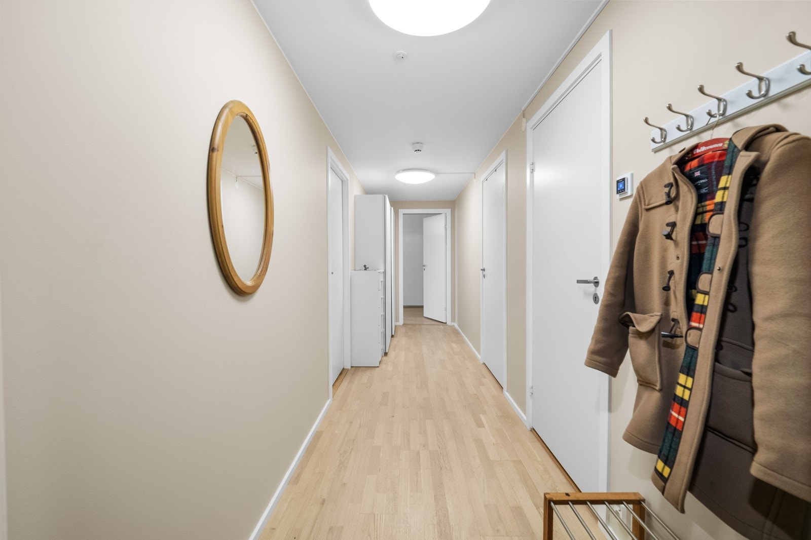 I enden av entreen er det en romslig skyvedørsgarderobe med hvite fronter. Galleribilde