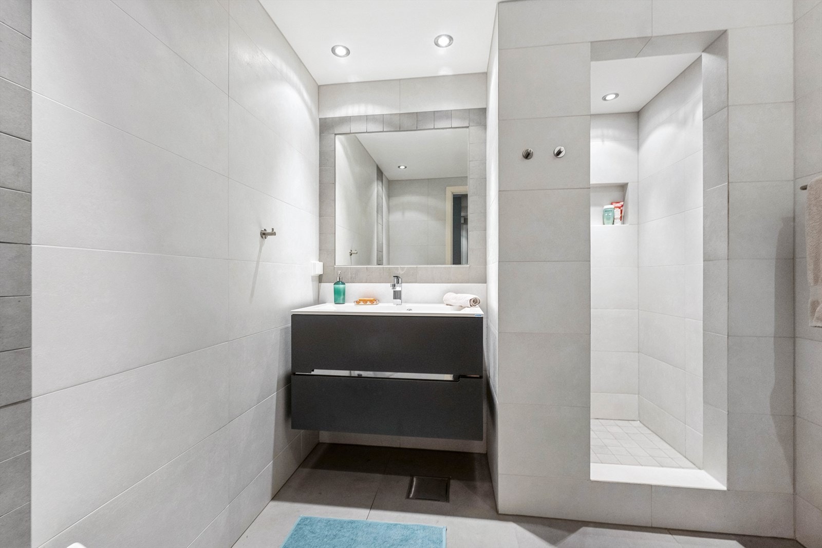 Badet er lyst og pent og fliser på gulv og vegger. Varmekabler i gulvet. Det er tatt hull i vegg og målt etter fukt. Ingen fukt ble påvist. Galleribilde
