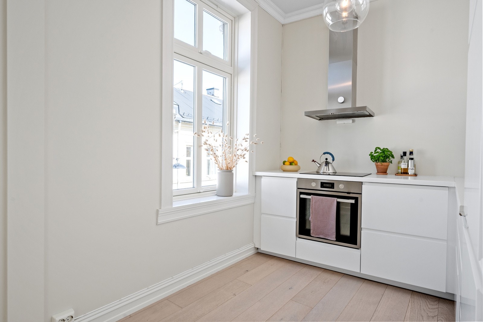 Stilrent kjøkken fra 2019 med hvite slette fronter og laminat benkeplate. Galleribilde