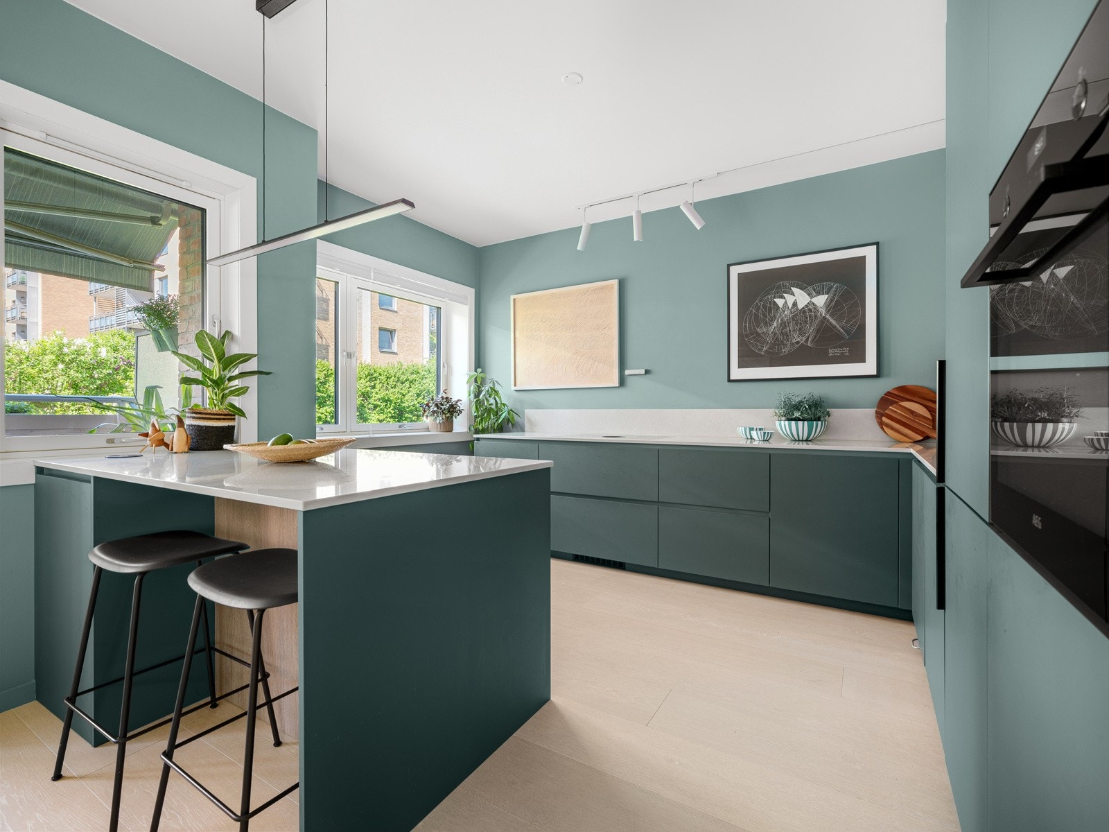 Innredningen har glatte grønne fronter i motstandsdyktig nanolaminat og benkeplate i stein av høy kvalitet fra Silestone i fargen Desert Silver. Galleribilde