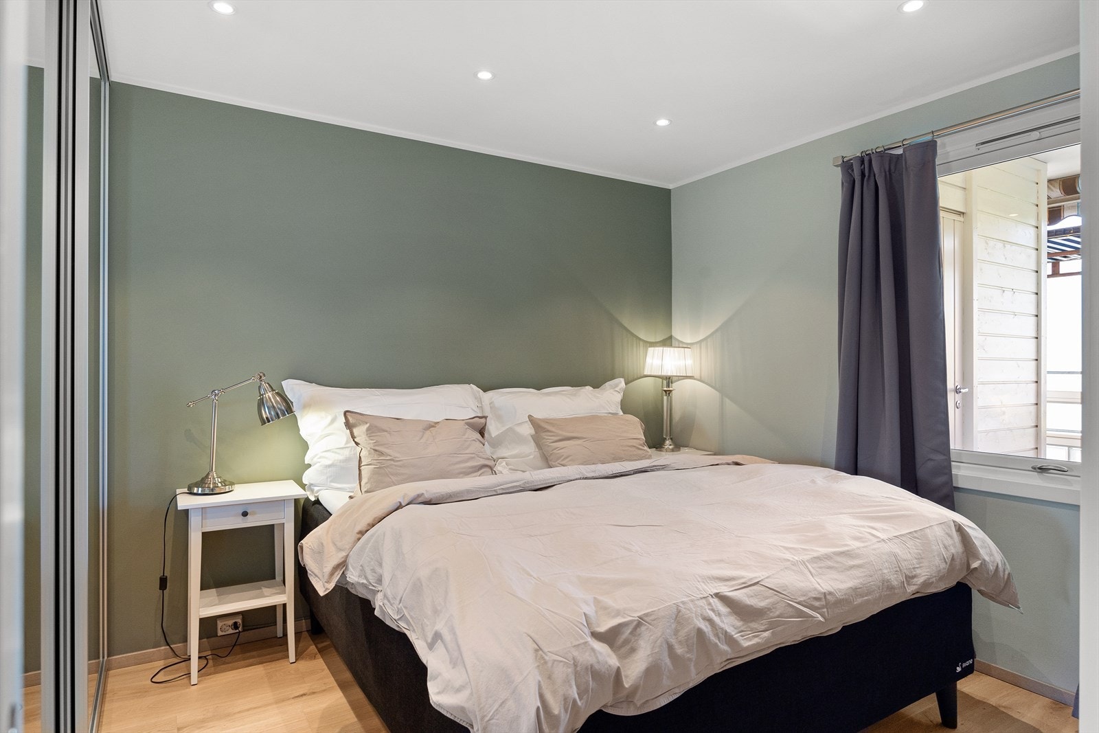 - Romslig soverom med plass til dobbeltseng med tilhørende nattbord - Galleribilde