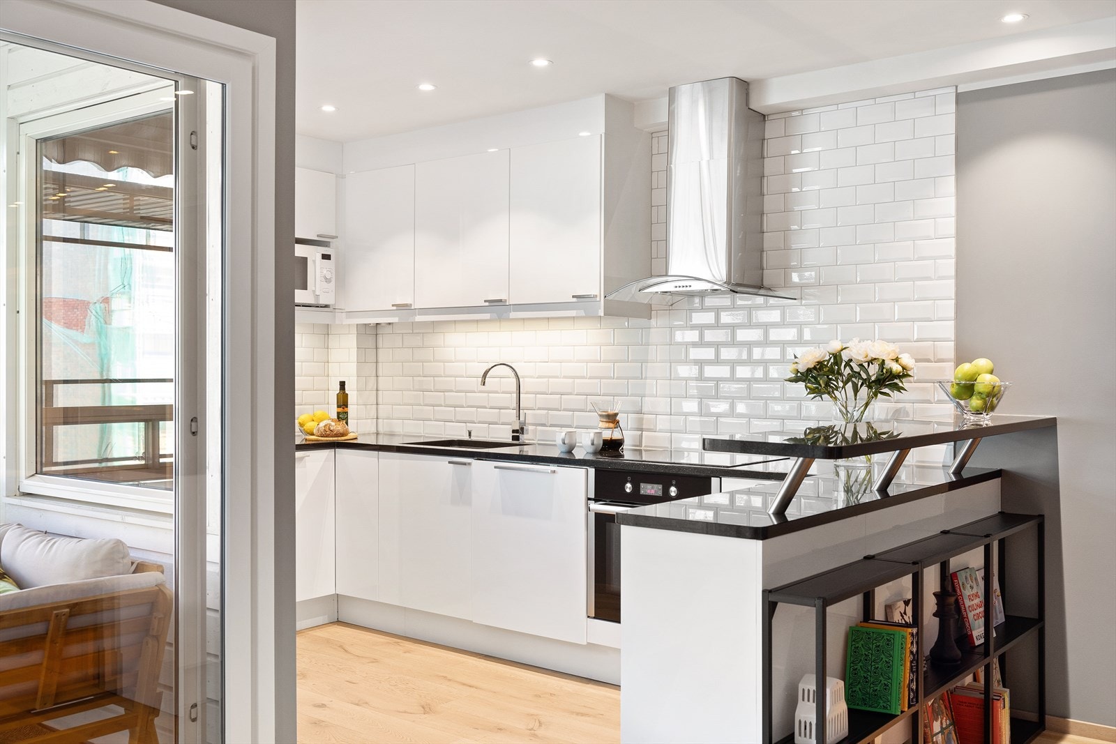 - Kjøkkeninnredning med glatte fronter. Benkeplate av stein med nedfelt vask- og skyllekum. Fliser og belysning over benkeplaten - Galleribilde