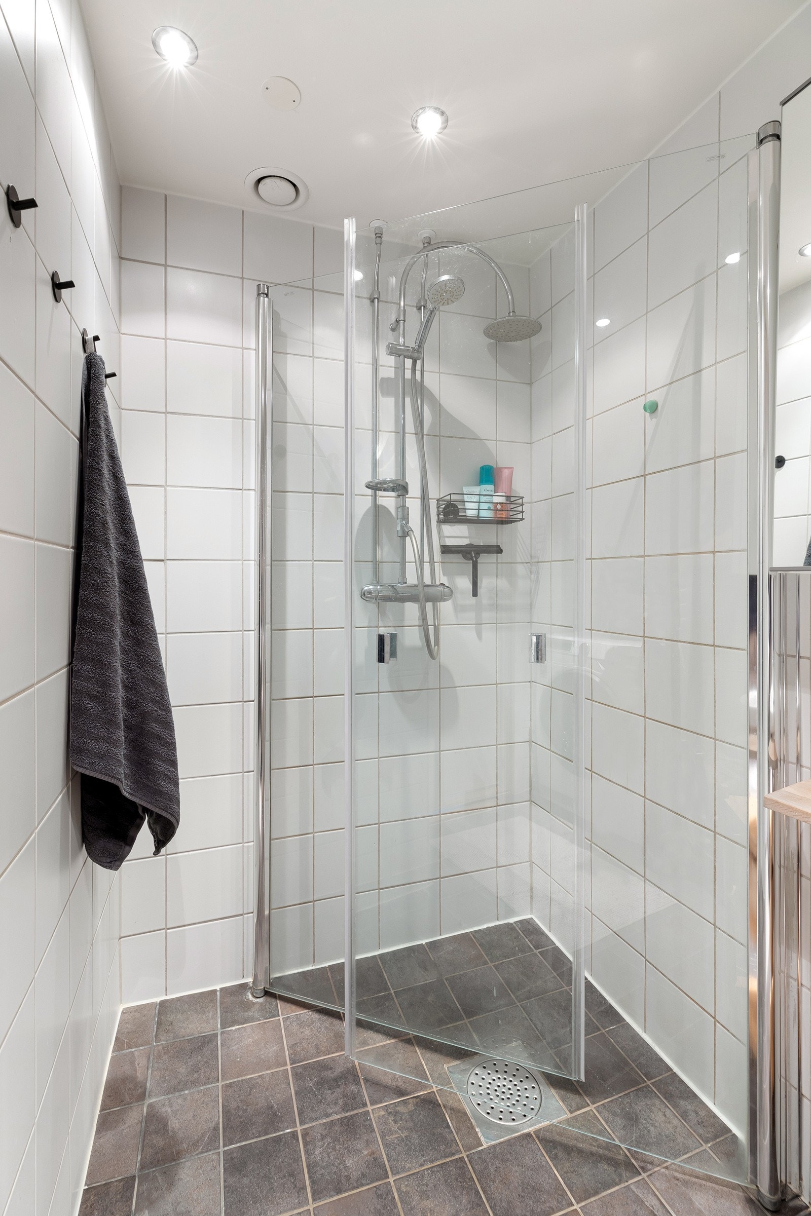 Badet inneholder dusjhjørne, veggmontert toalett, servant og opplegg for vaskemaskin Galleribilde