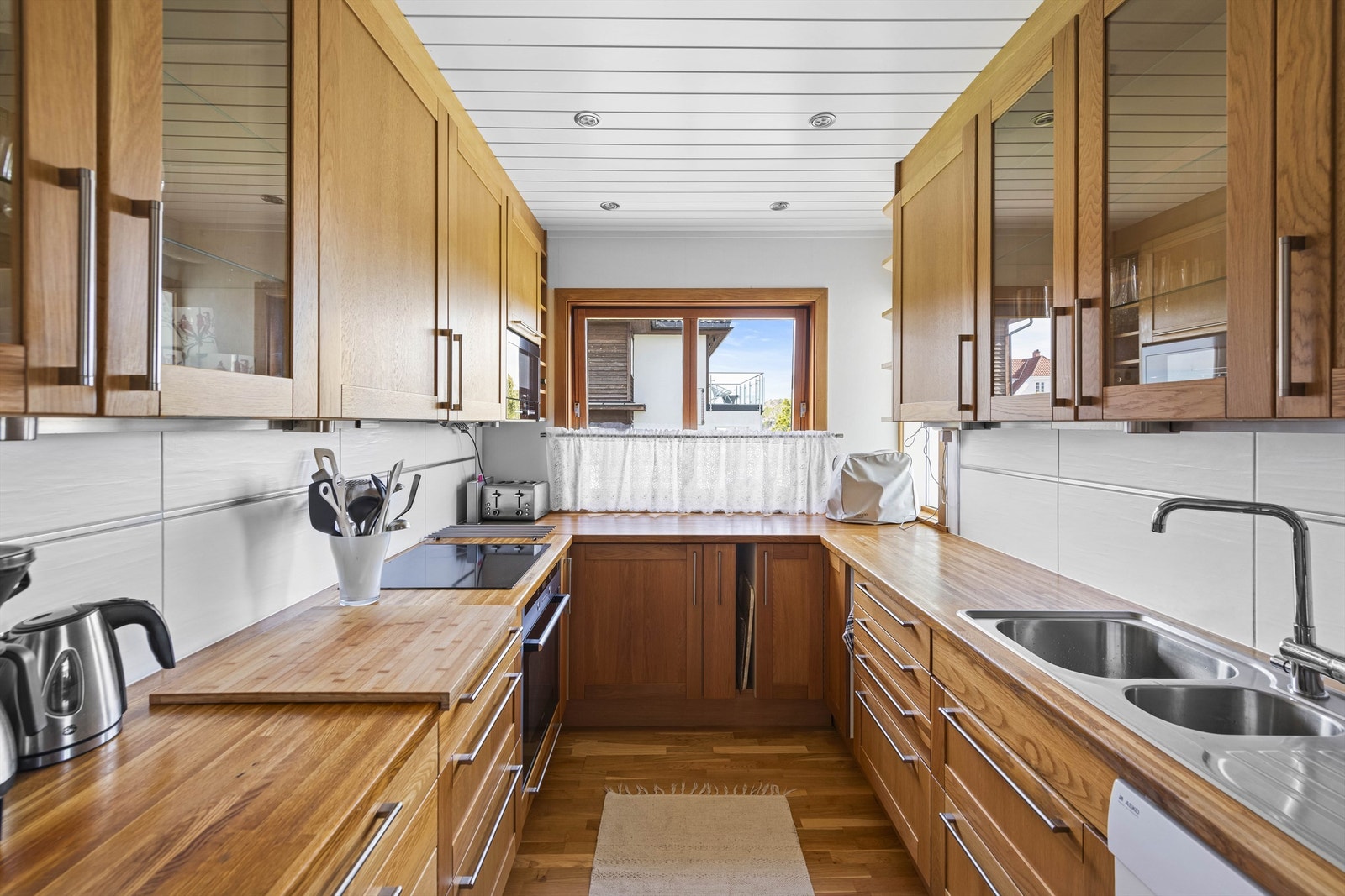 Eldre kjøkken i heltre og fliser mellom over-/underskaper Galleribilde