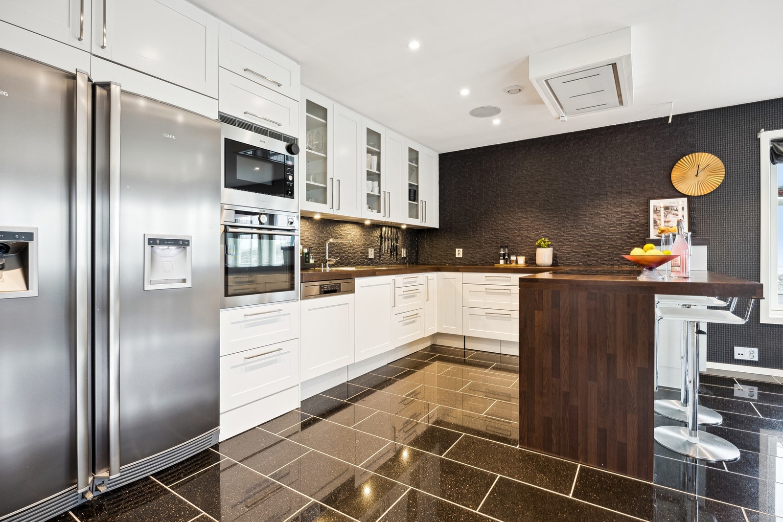 Kjøkkenet er godt utstyrt med blant annet ventilator i himling, integrerte hvitevarer og side by side kjøl og frys med vanndispenser og isbitmaskin Galleribilde