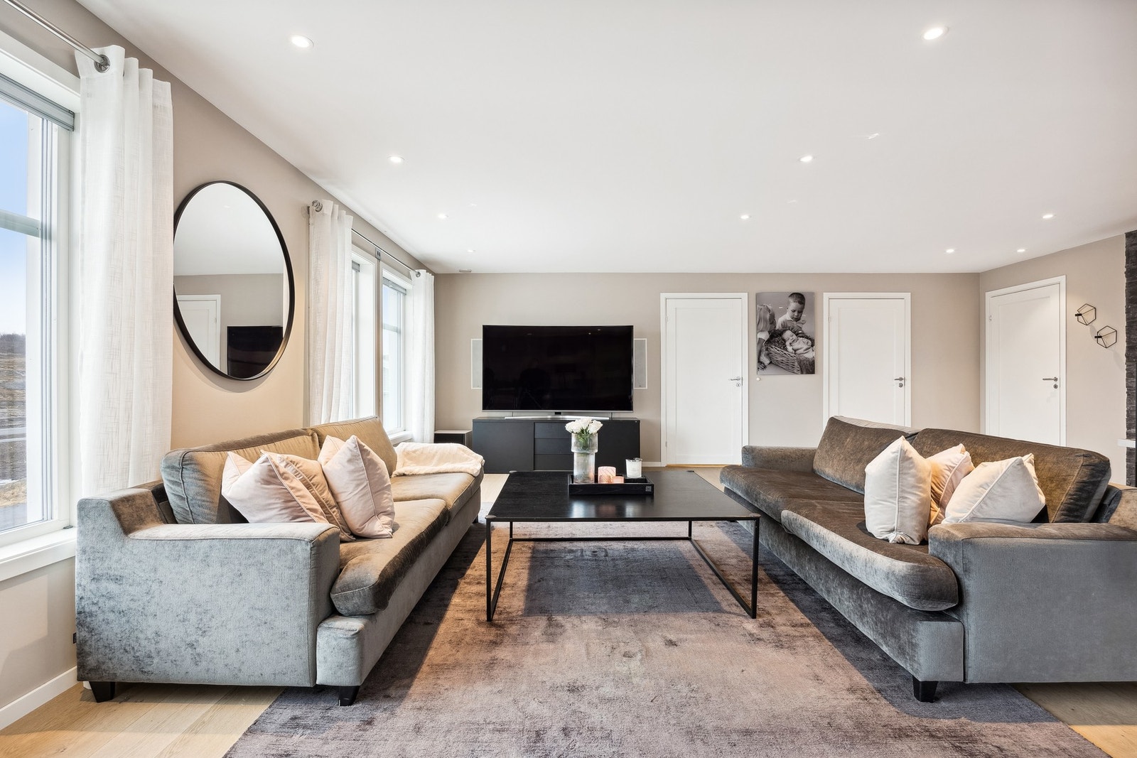 Stuen er malt i en tidløs og nøytral farge. Legg også merke til integrert lydanlegg i vegg ved TV Galleribilde