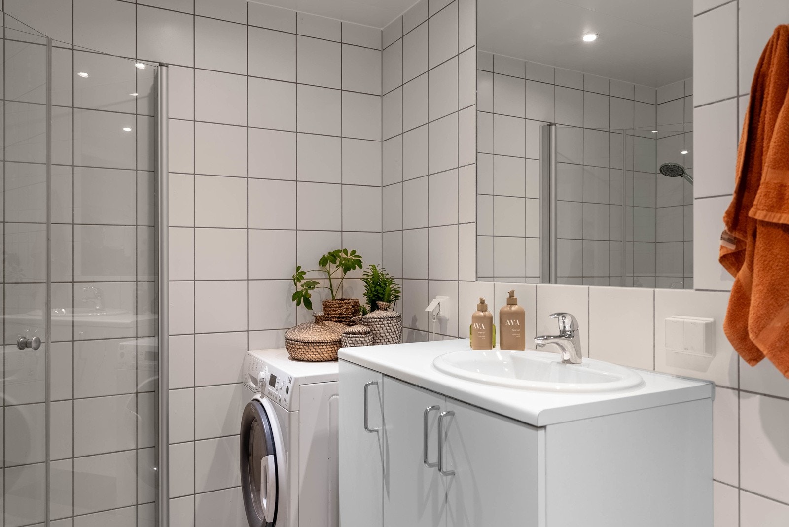 Helfliset baderom med himling belagt med himlingsplater av metall med innfelte downlights. Galleribilde