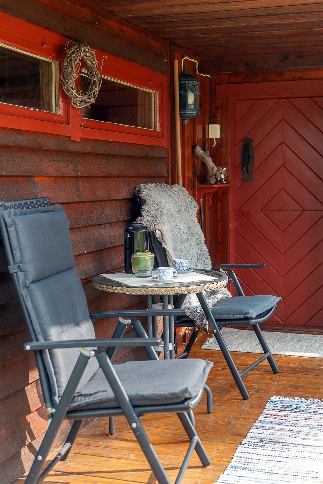 Fin kaffeplass under tak ved inngangen. Overbygget inngangsparti. Galleribilde