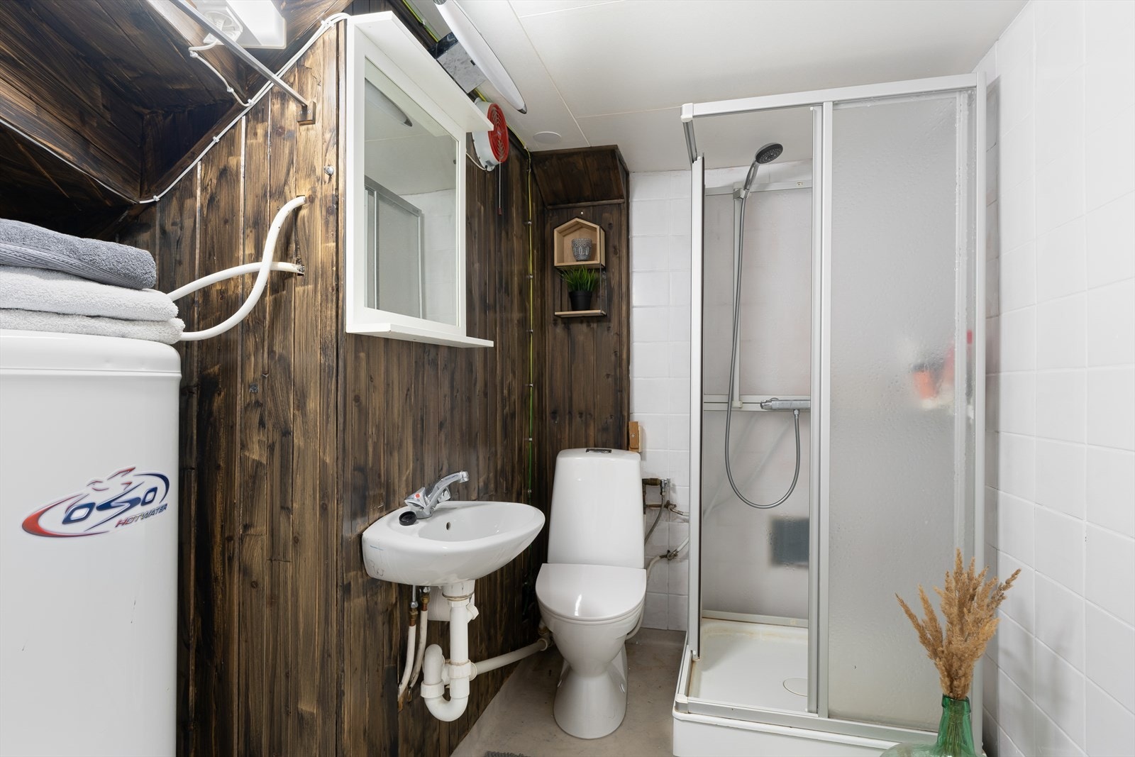Bad med vinylbelegg på gulv, innredet med wc, dusjkabinett og vask Galleribilde