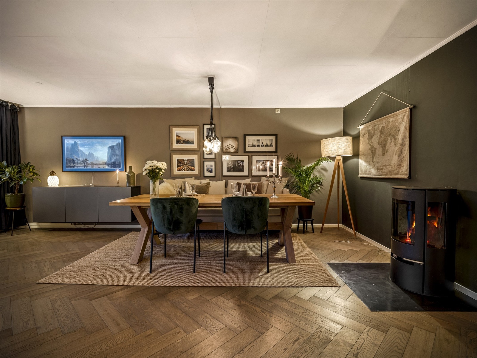 Stuens moderne peis står sentralt i rommet, til glede for både sofakroken og spisebordet. Galleribilde