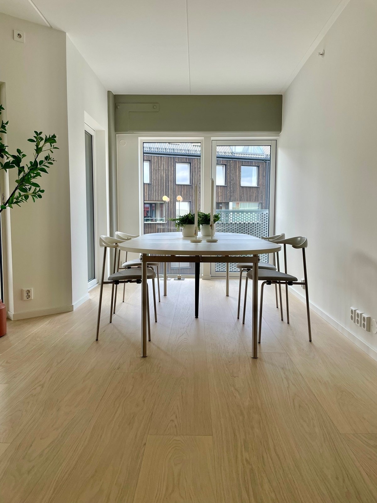 Lyst og innbydende spisestueområde med store vinduer. Galleribilde