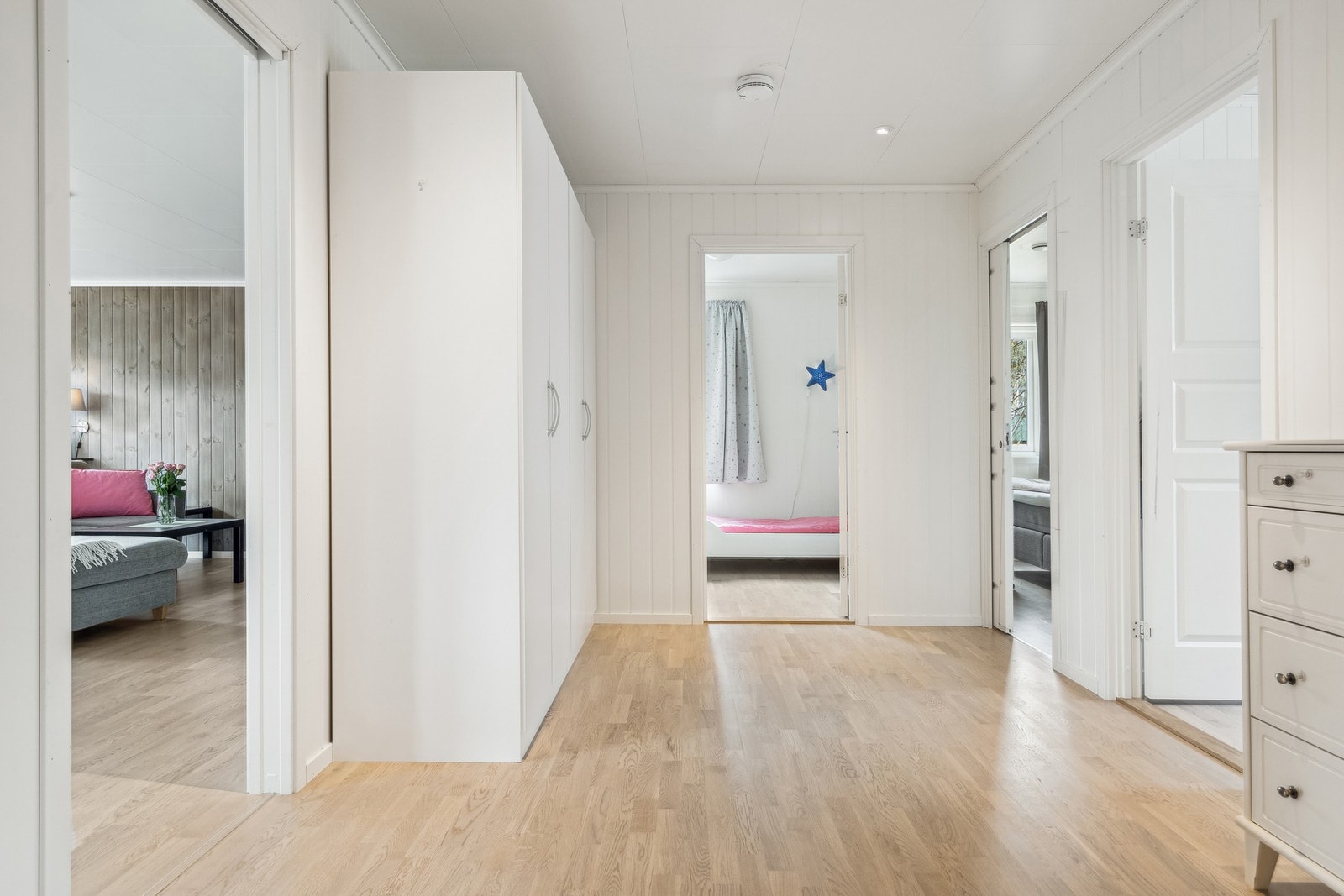 Romslig mellomgang med garderobeskap og skyvedør inn til bl.a. stuen. Galleribilde