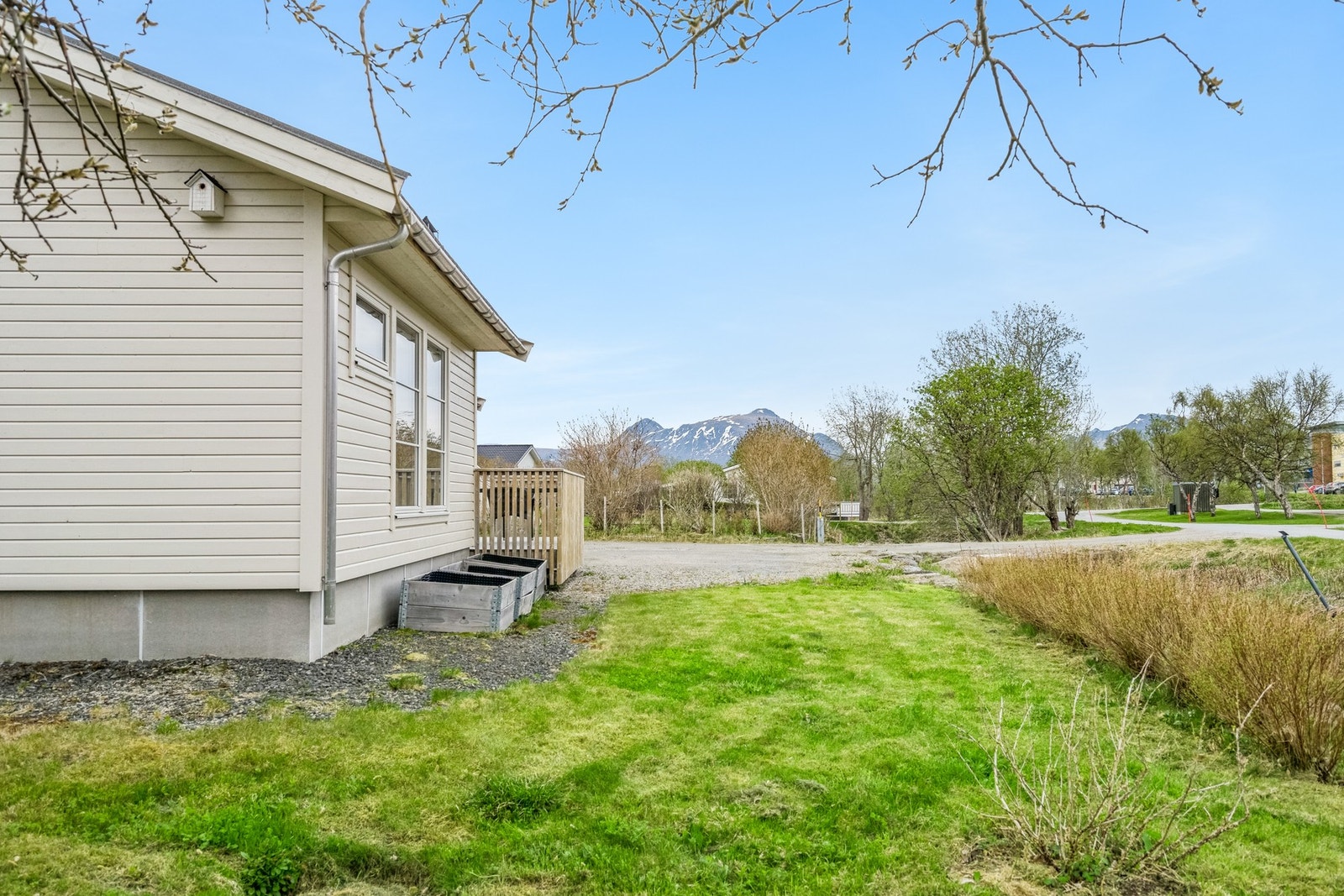 Opparbeidet tomt med plen og gruset parkering. Galleribilde