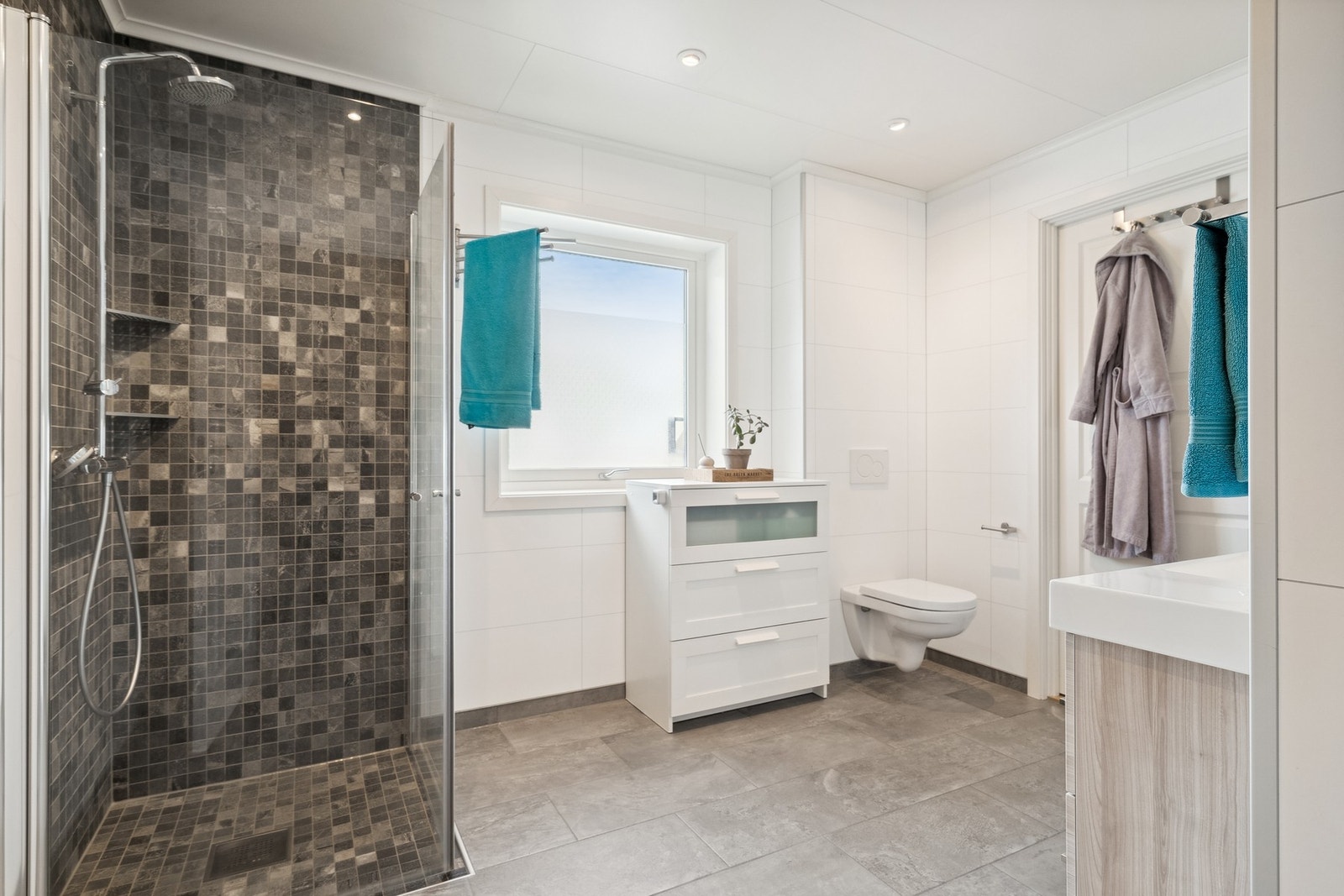 Flott dusjhjørne med både regndusj og hånddusj. Praktisk med vegghengt toalett for enkel rengjøring. Galleribilde