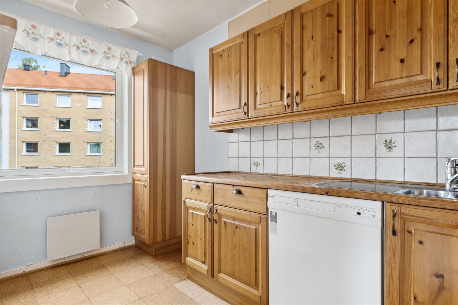 Integrert oppvaskmaskin og kullfilterventilator over kokeplass. Galleribilde