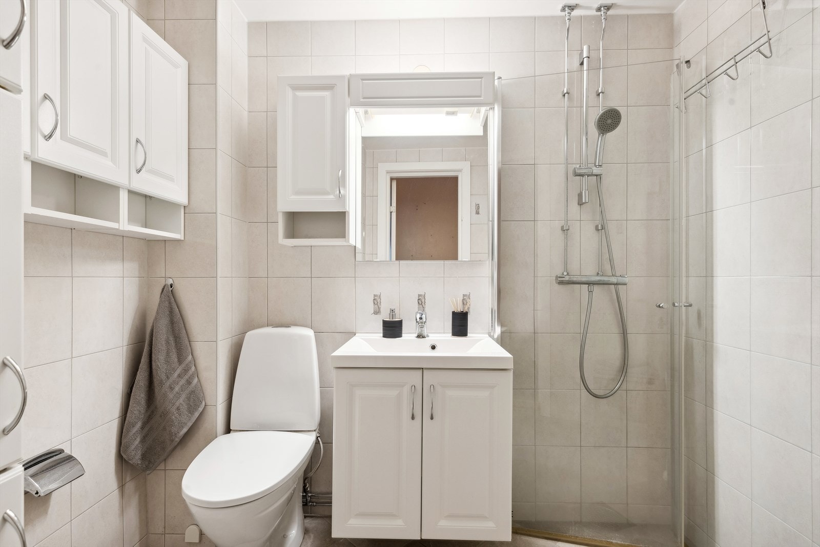 Videre er badet innredet med klosett, servant med innredning og dusjhjørne med svingbare glassdører. Naturlig avtrekk og opplegg for vaskemaskin. Galleribilde