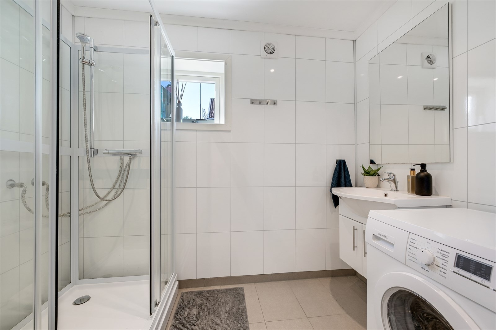 Bad/wc med dusjkabinett og opplegg for vaskemaskin. Galleribilde