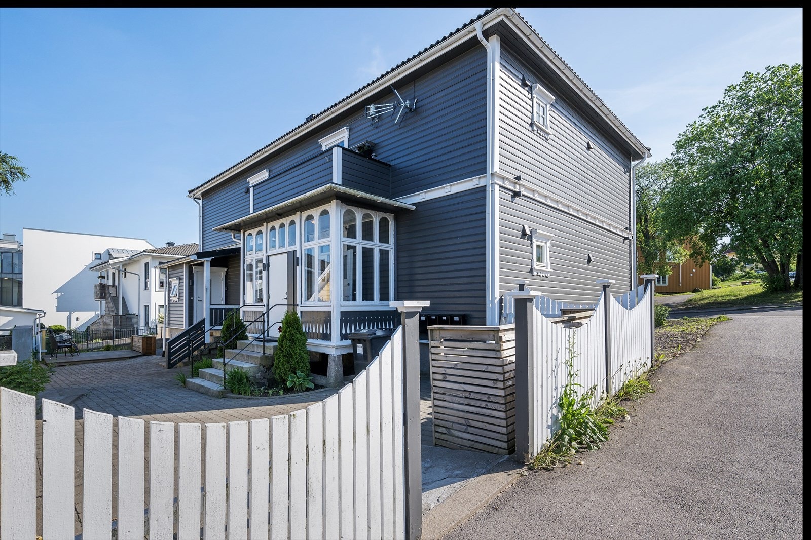 Fasade med steinlagt felles uteområde i forkant, samt markterrasse. Galleribilde