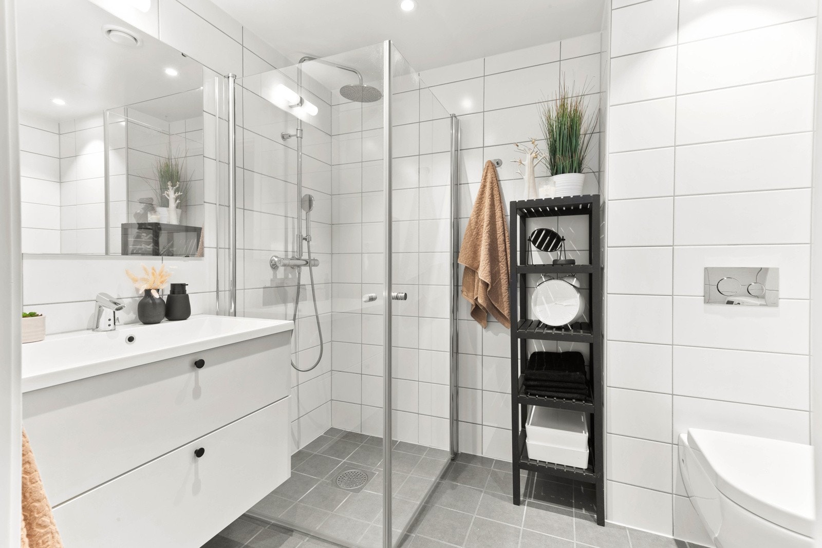 Gode oppbevaringsmuligheter i stort moderne servantskap. Dusjhjørne med innslagbare glassdører i klart herdet glass. Galleribilde