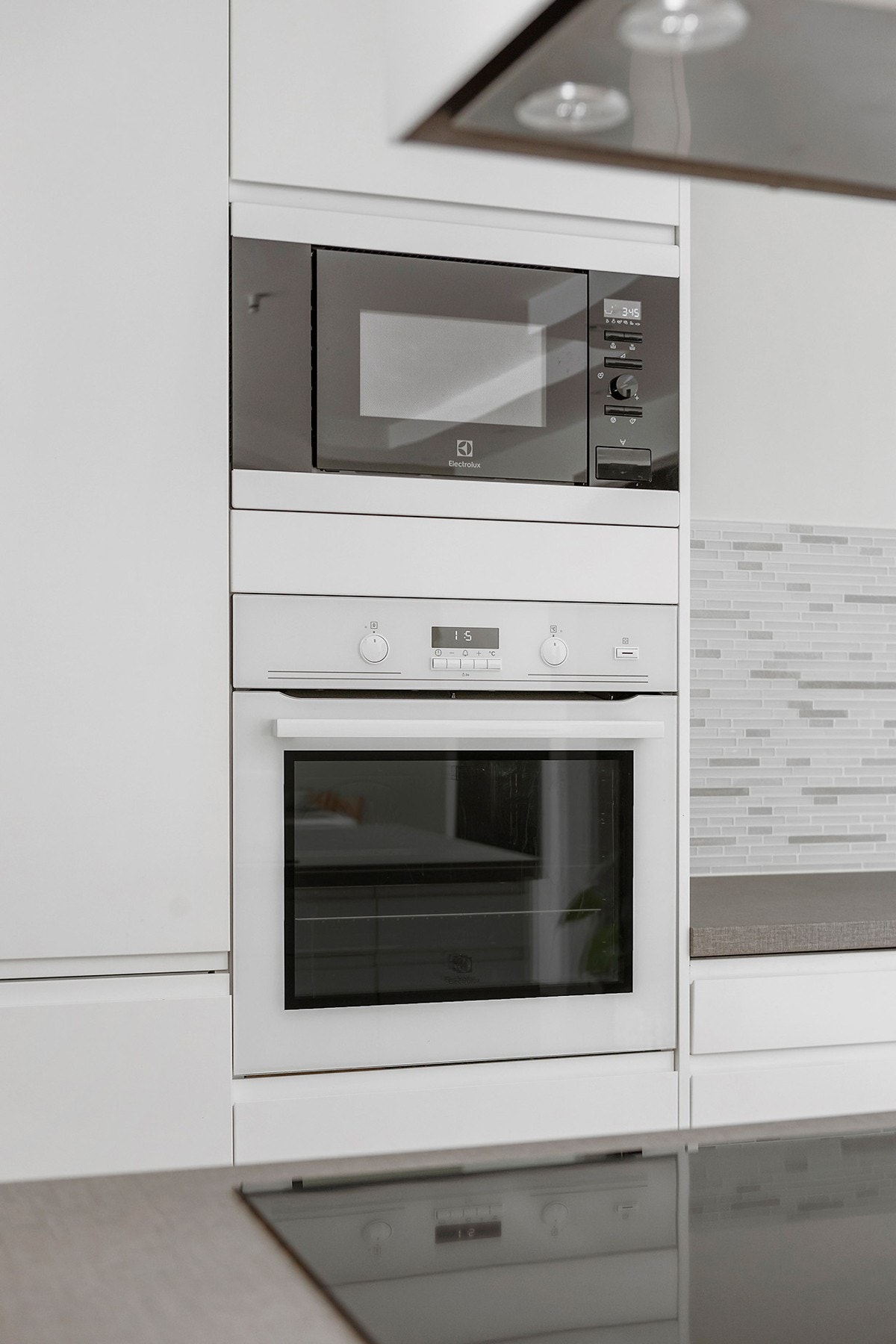 Integrerte hvitevarer og kjøkkenøy med koketopp Galleribilde