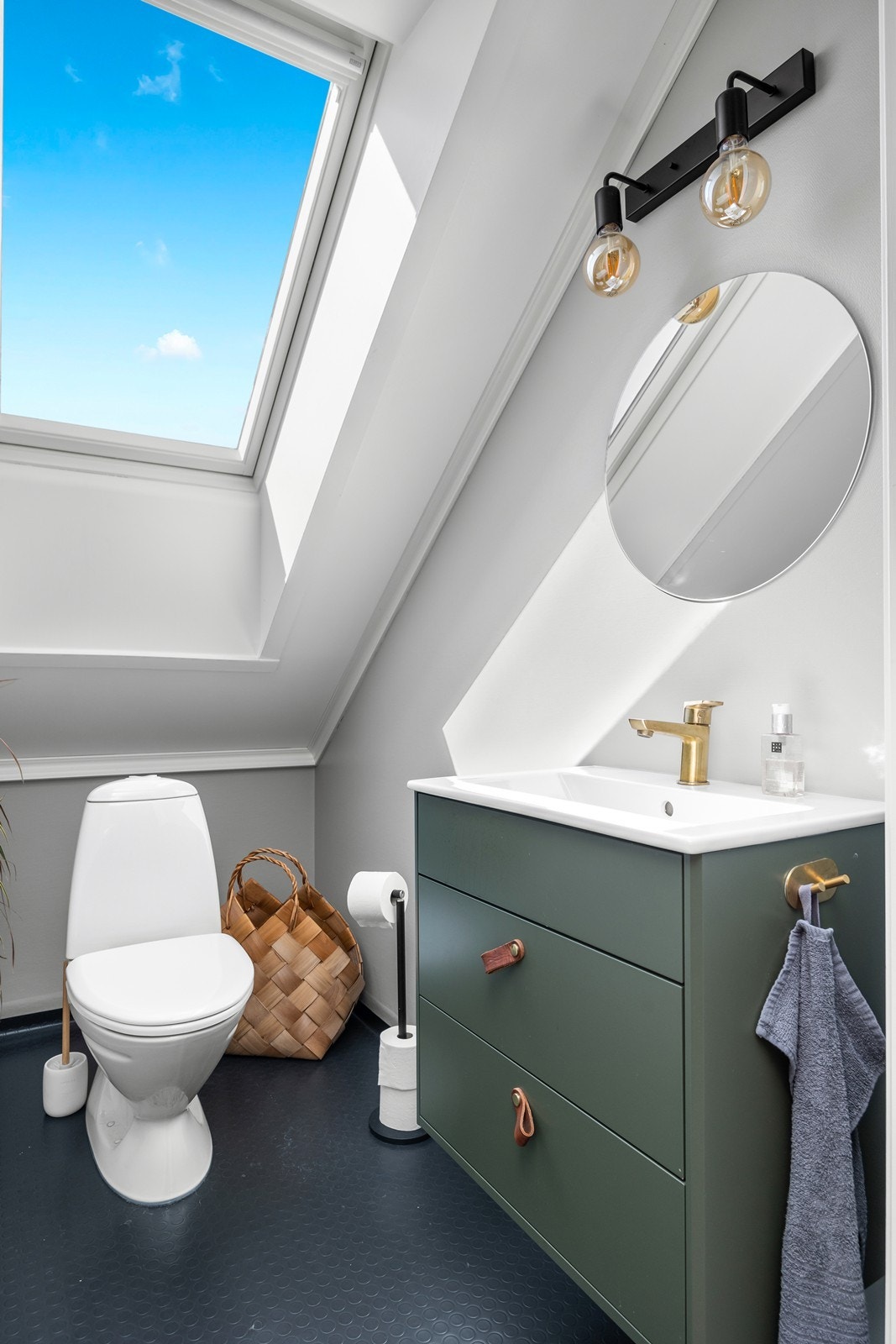 Badet er utstyrt med toalett, badekar og servant med underskap Galleribilde