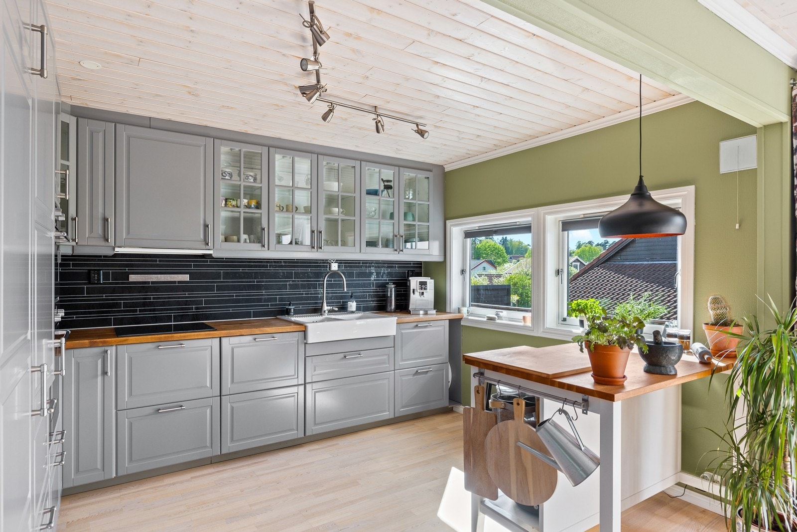 Kjøkkenet har innredning med profilerte fronter og integrerte hvitevarer Galleribilde