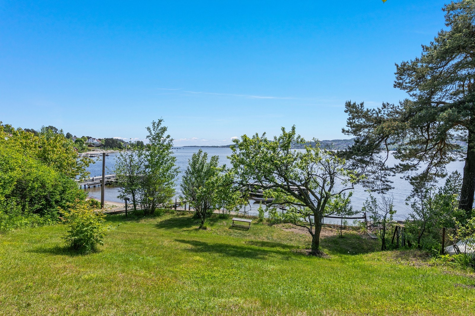 Pent opparbeidet hage med stor plen og enkel adkomst til brygge og sandstrand Galleribilde