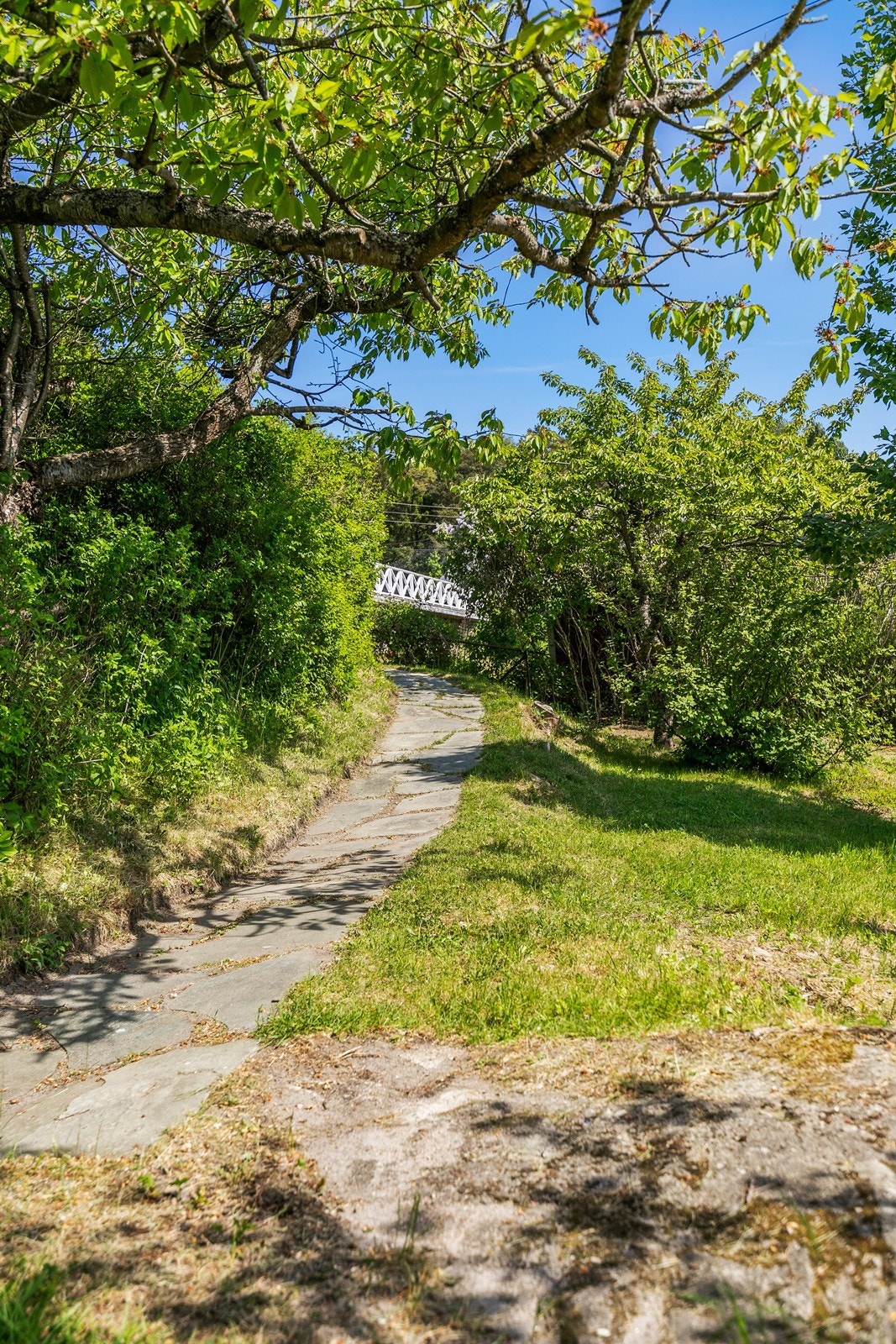 Fra brygga er det steinlagt sti opp til huset Galleribilde