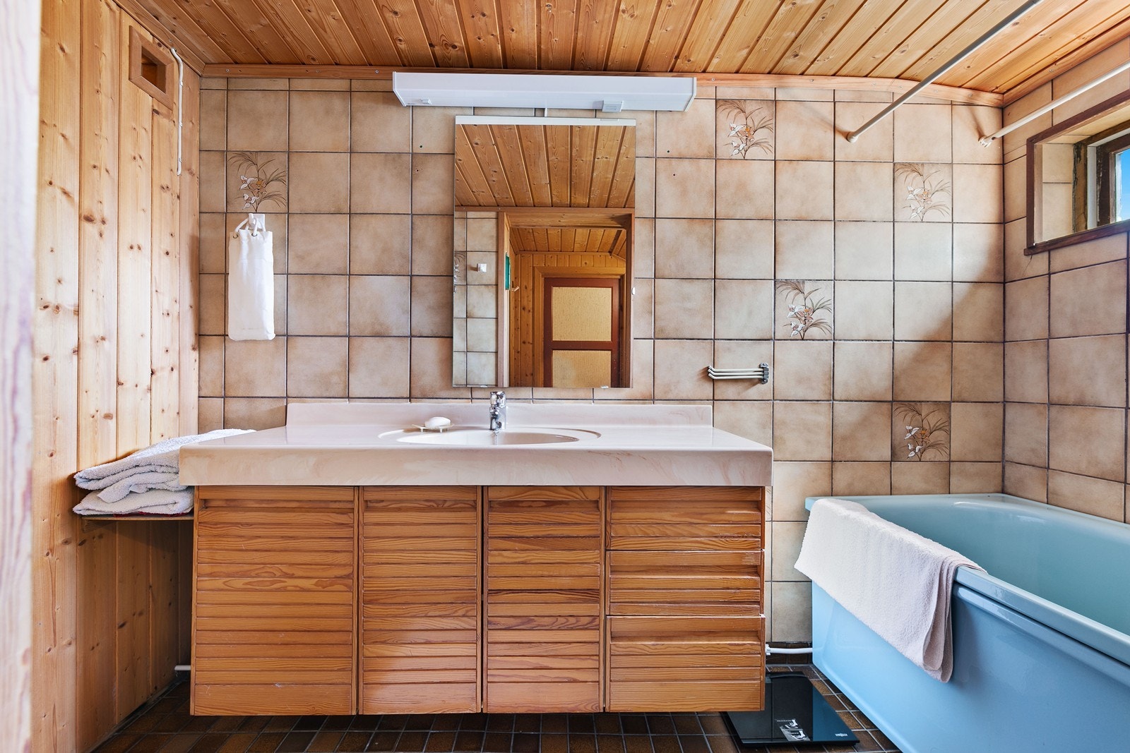 Stort bad i underetasjen med servant i innredning, badekar, dusjnisje, gulvmontert toalett og badstue Galleribilde