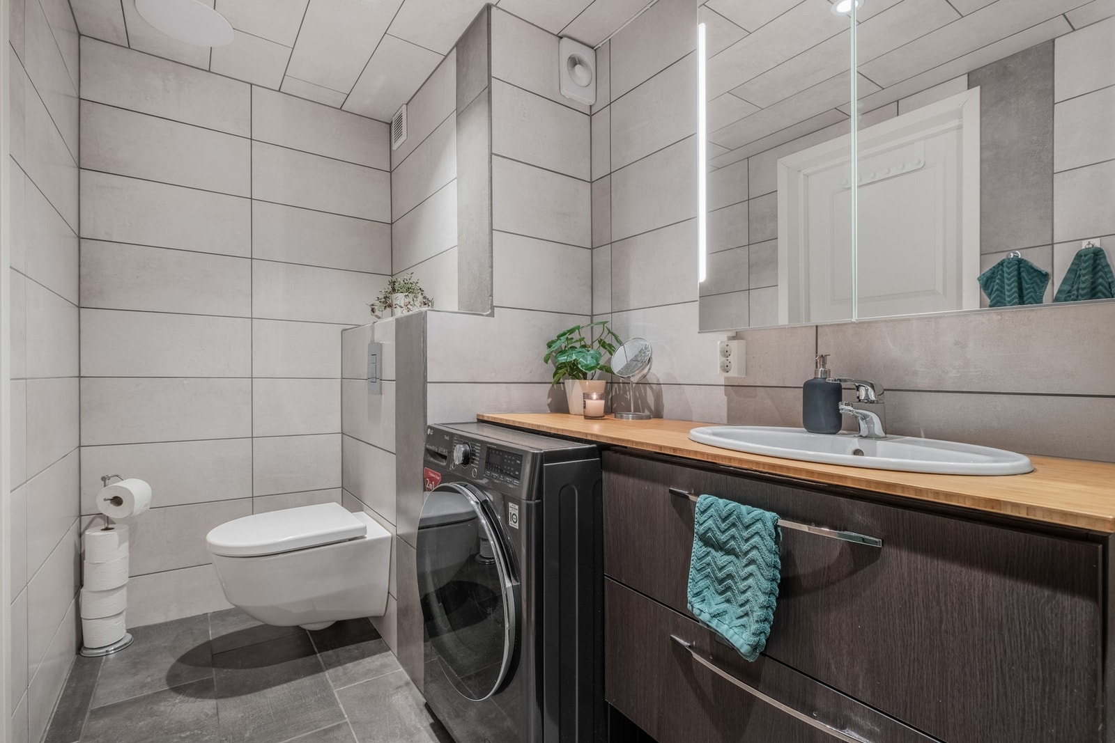 Badet er på ca. 4,9 m², store fliser og har vegghengt toalett Galleribilde