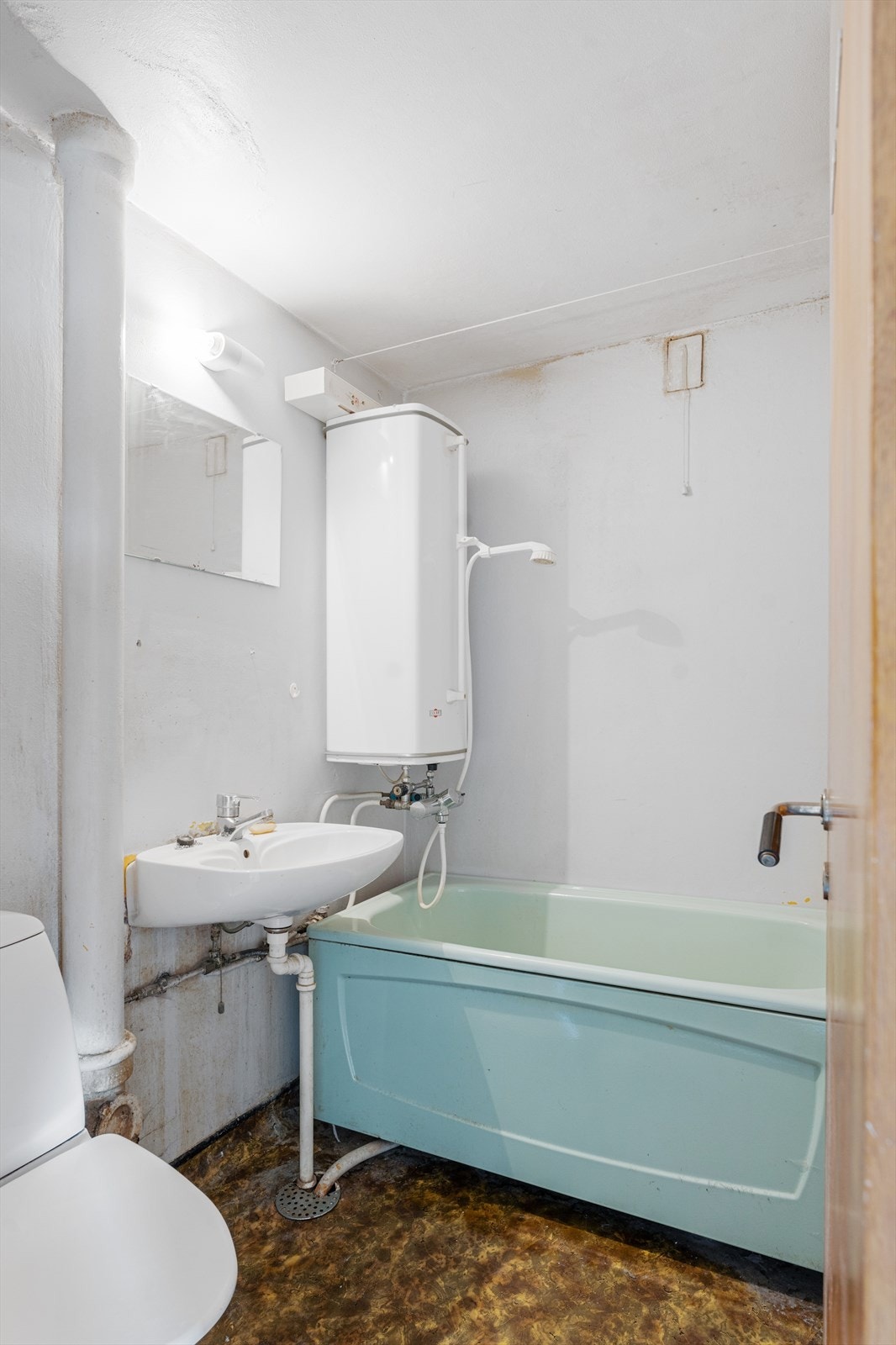 Baderom med badekar, toalett, vask og speil. Galleribilde