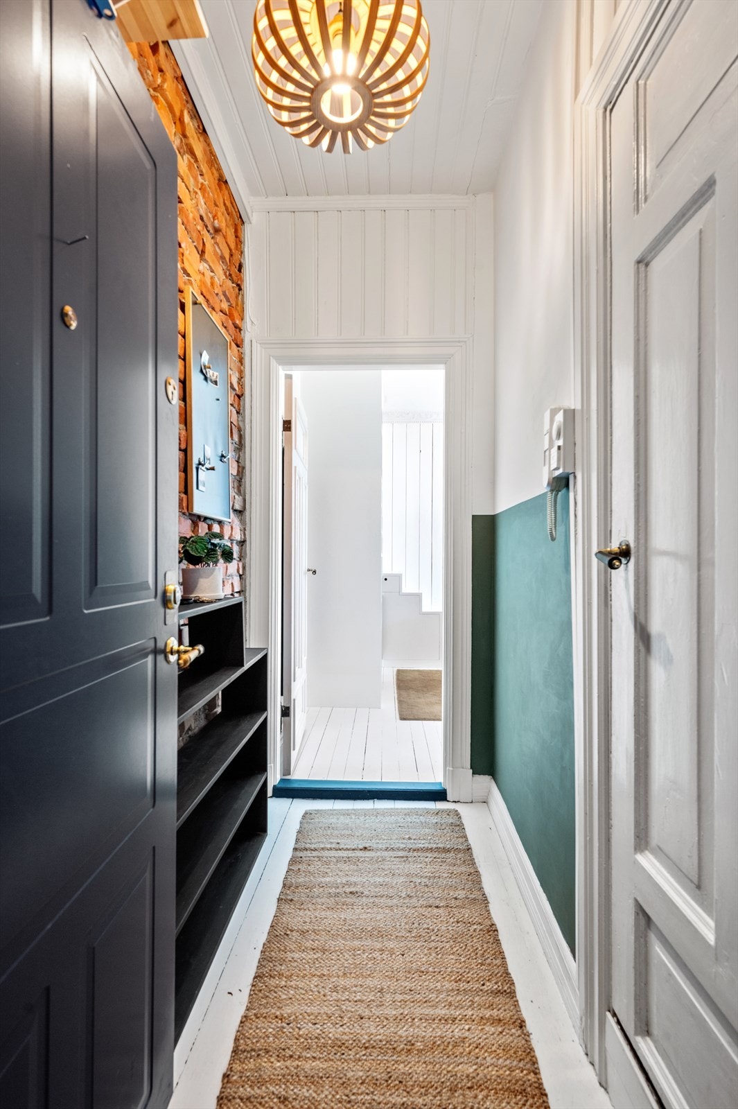 Velkommen inn! Sjarmerende entré med tregulv og eksponert teglstein på den ene veggen. Galleribilde