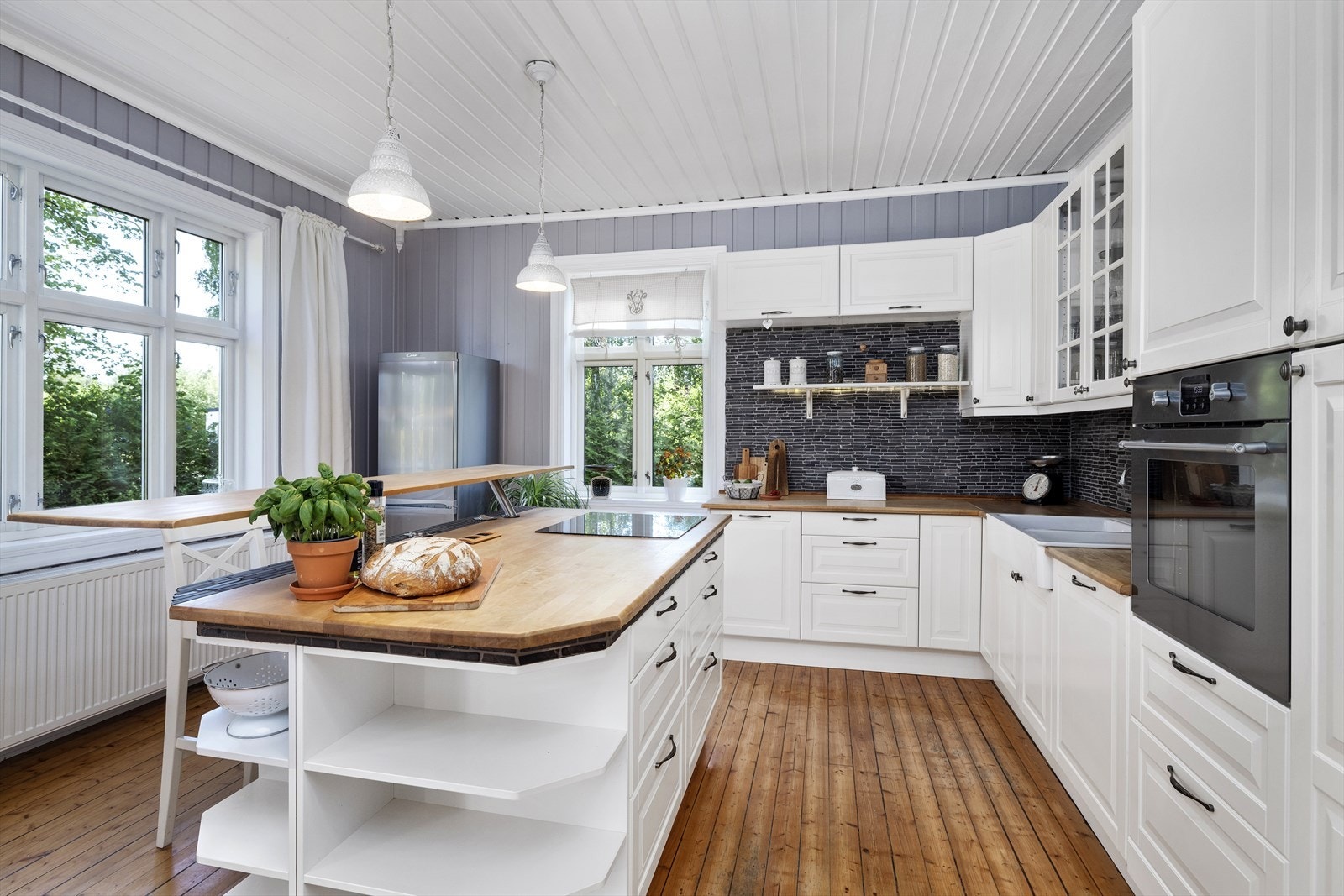 De store vinduene gir rikelig med naturlig lys og gir en hyggelig utsikt til grønne omgivelser. Et kjøkken perfekt for både matlaging og sosiale sammenkomster. Galleribilde