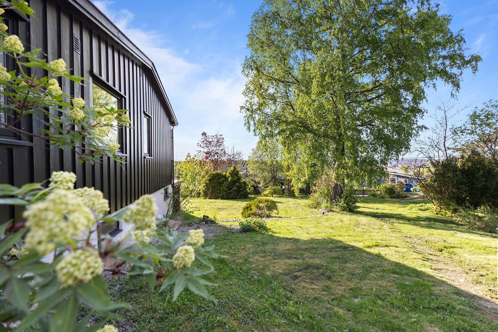 Boligen omkranses av en stor og frodig tomt. Galleribilde