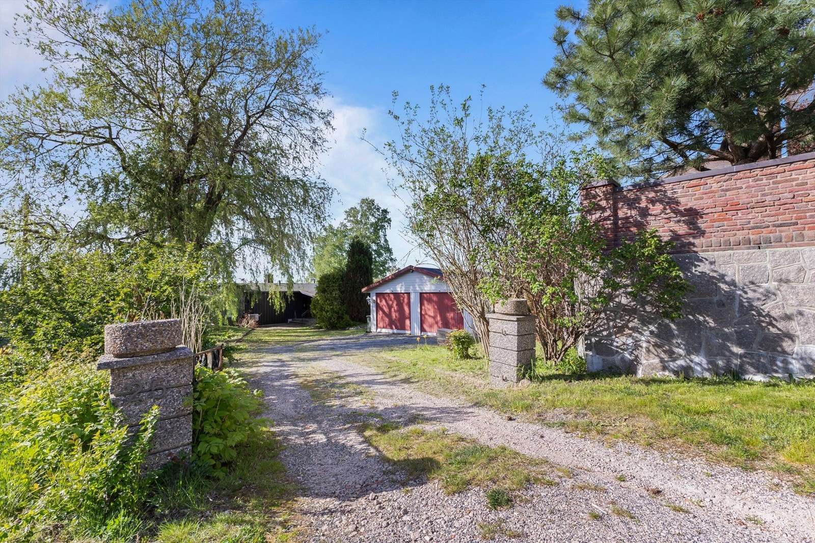 Eiendommen har innkjørsel fra oversiden. Garasjen er hendig plassert øverst på tomten. Galleribilde