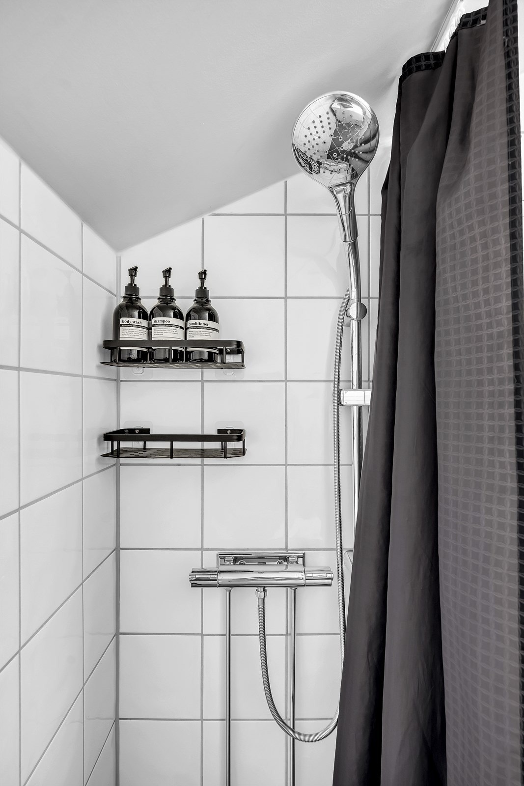 Badet gulvstående toalett og dusj på gulv med dusjforheng. Det er opplegg for vaskemaskin. Galleribilde
