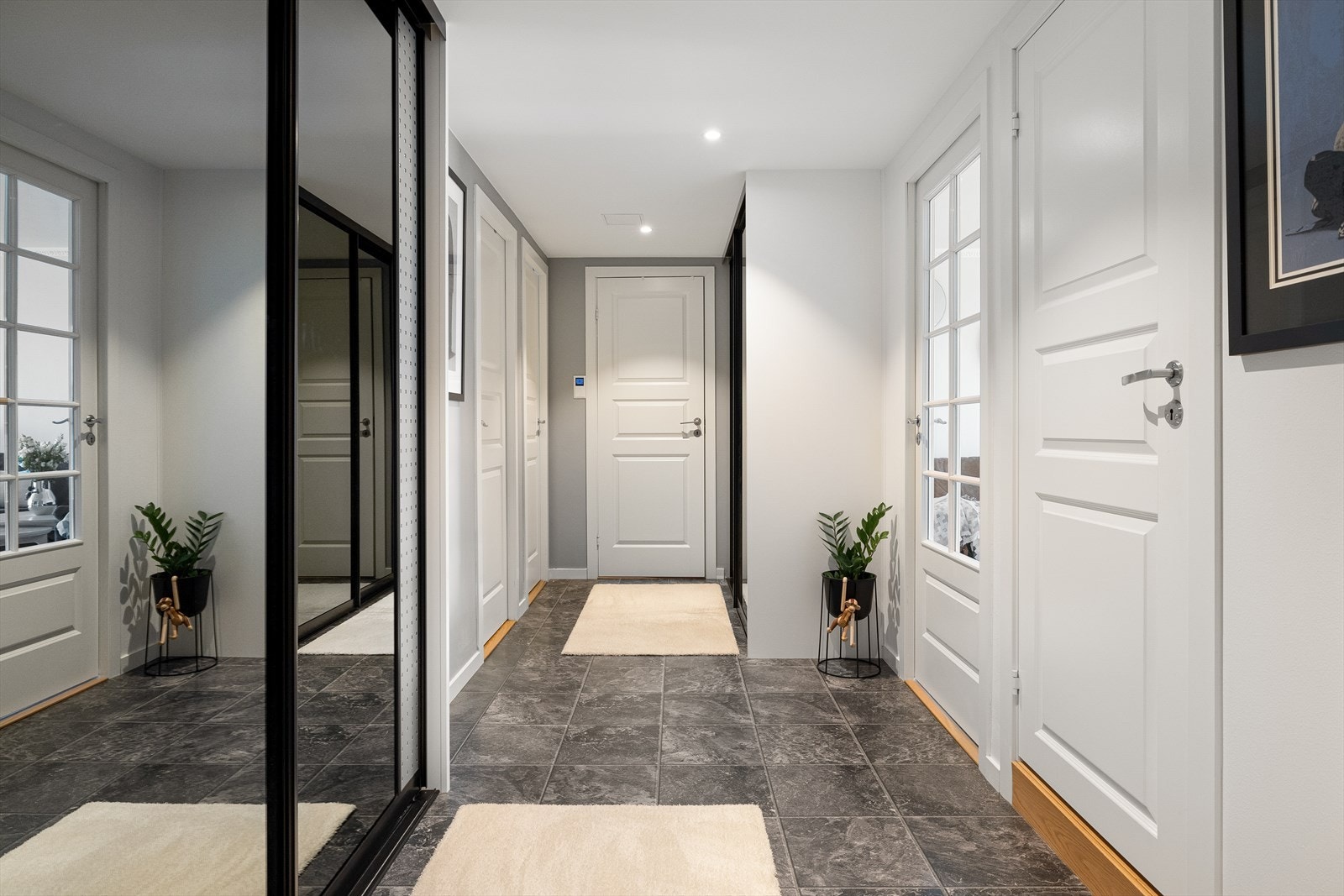 Entrèen er lys og trivelig med god plass til å sette fra seg sko og henge yttertøy i stor skyvedørsgarderobe med speilfronter. Galleribilde