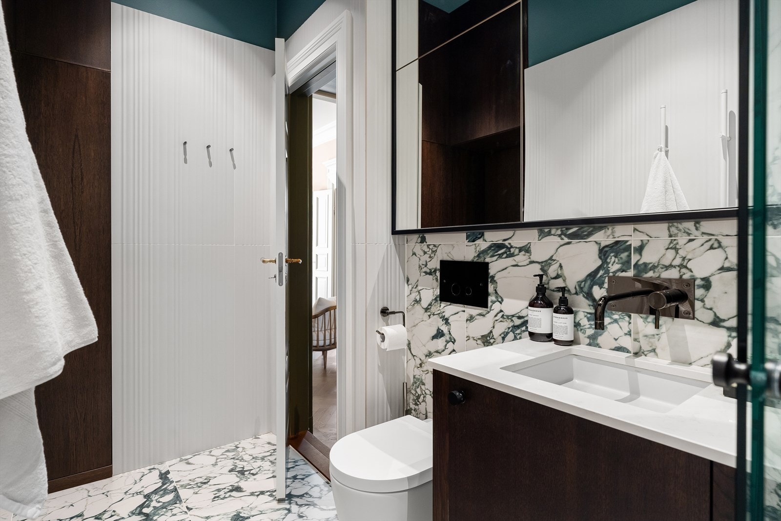 Plassbygde løsninger fra Brubakken Home - blant annet med et spesialbygget skap som rommer varmtvannstank, vaskesøyle, støvsuger og mer. Galleribilde