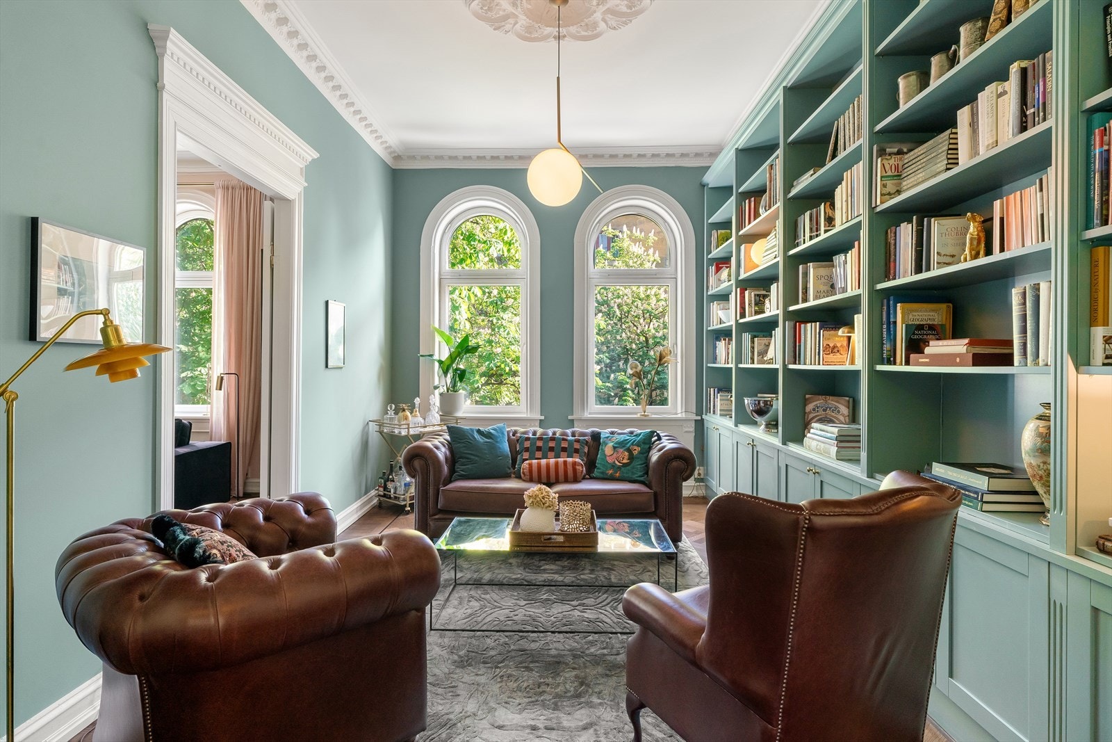 Bibliotek med snekkerbygget bokhylle malt i den klassiske Oval Room Blue-fargen fra Farrow & Ball. Galleribilde