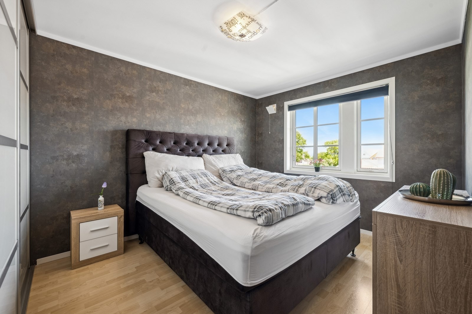 Leilighetens har et svært godt hovedsoverom. Her med mer er nok plass til dobbeltseng med nattbord i tillegg til kommode. På den ene langveggen går det også en romslig skyvedørsgarderobe. Galleribilde