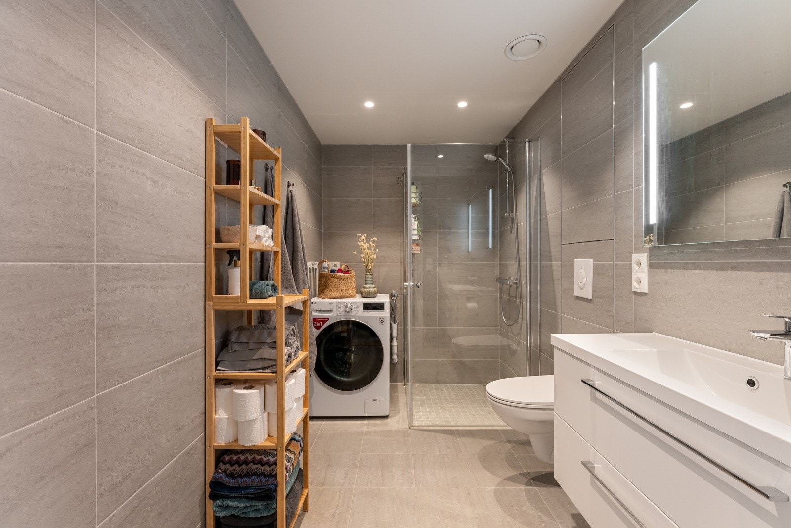 Boligen har et lekkert, flislagt bad fra byggeåret som er meget romslig. Badet er utstyrt med dusjnisje med glassdører, vegghengt toalett og servant med innredning. Galleribilde