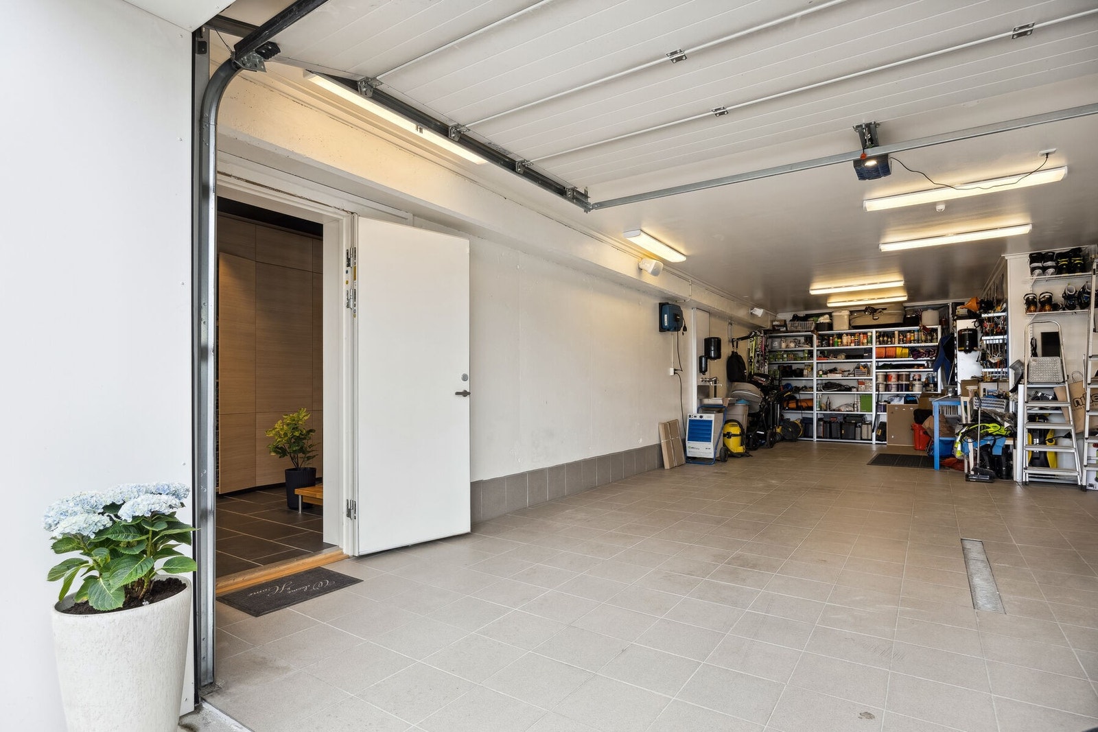 Garasje har flislagt gulv og direkte adkomst til gang i hovedboligen Galleribilde